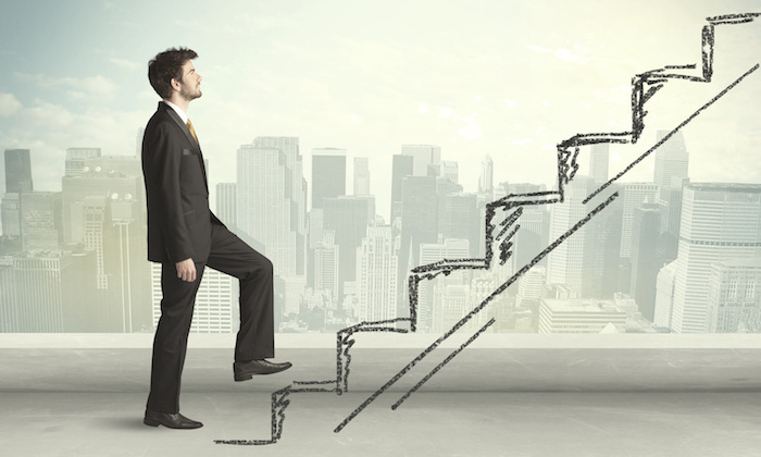 Business man climbing up on hand drawn staircase concept