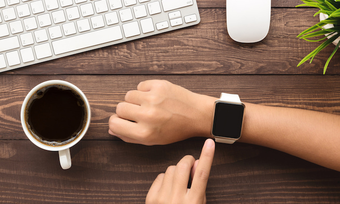 hand using smartwatch on desk top view