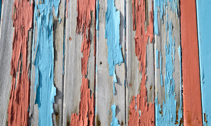 closeup of a old cracked fence with flaking paint.