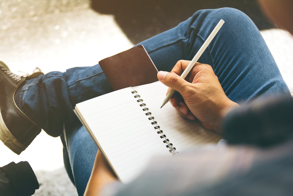 homem fazendo anotações em caderno