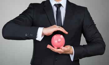 Unrecognizable businessman holding pink piggy bank