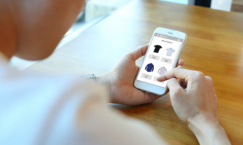 Man holding smartphone with choose shirt on ecommerce website