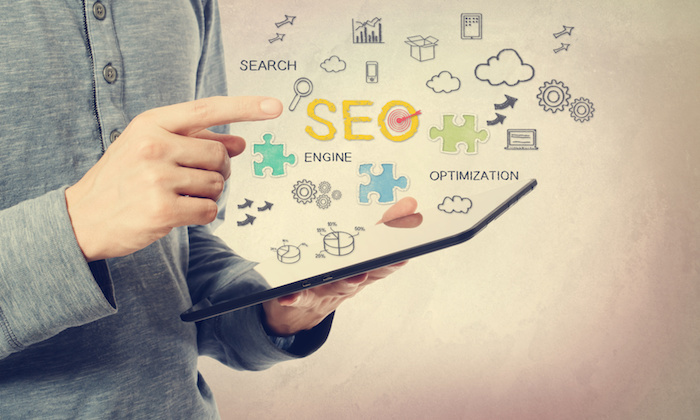 Young man pointing at SEO concept over a tablet