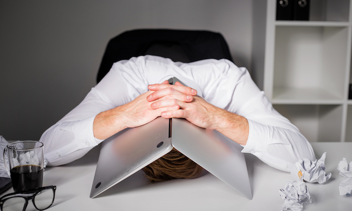 Man hiding under laptop