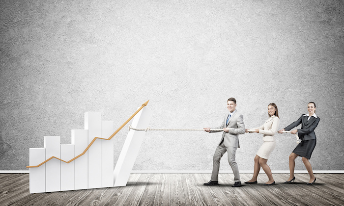 Businessteam working in collaboration pulling graph with rope as symbol of power and control