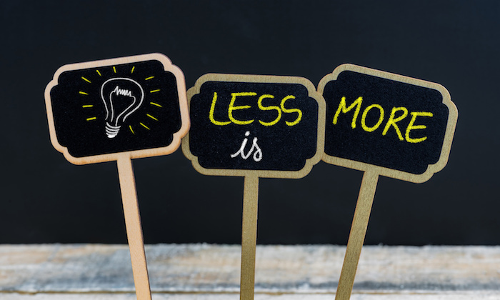 Concept message LESS IS MORE and light bulb as symbol for idea