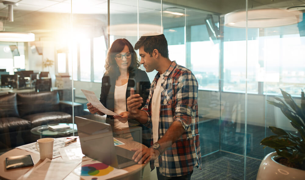 dupla trabalhando em sala de vidro em área de criação