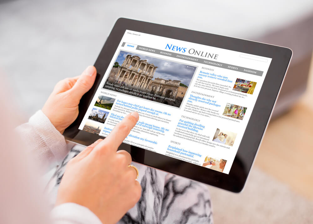 mão acessando site de notícias em tablet