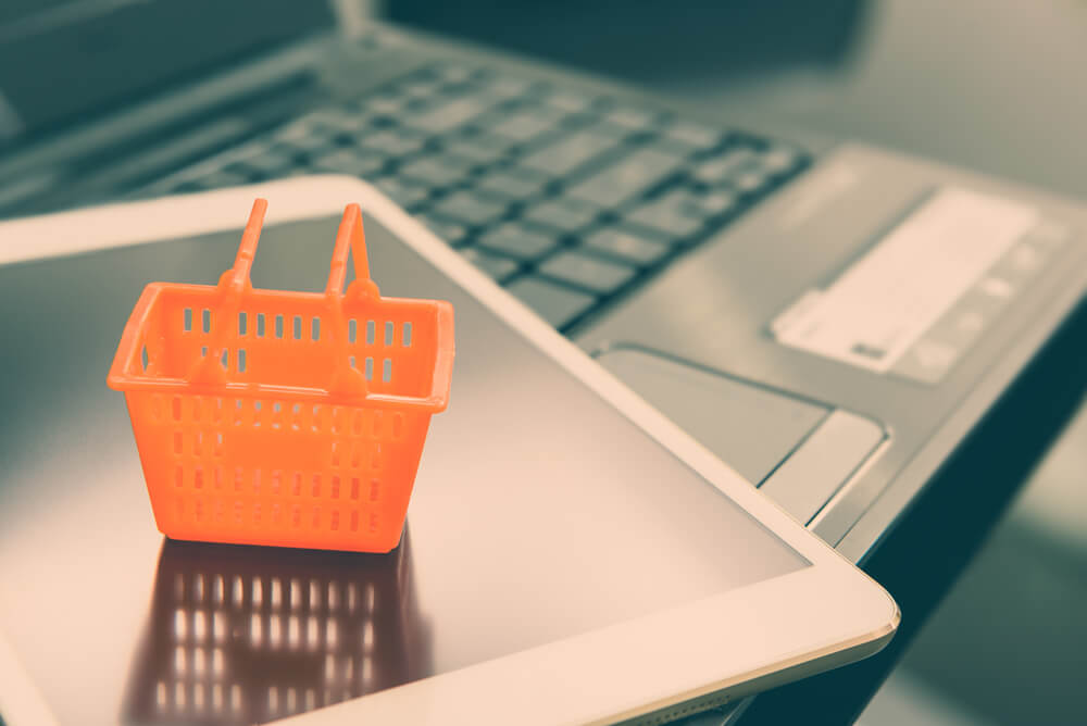 mini cesta de compras acima de tablet e laptop