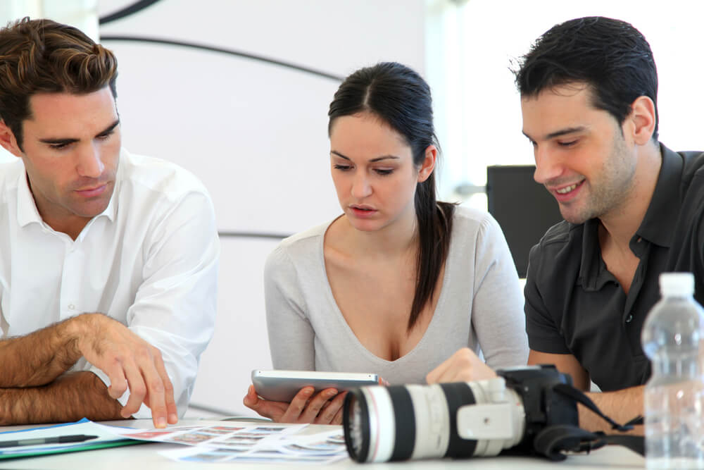 trio trabalhando sob mesa de escritório