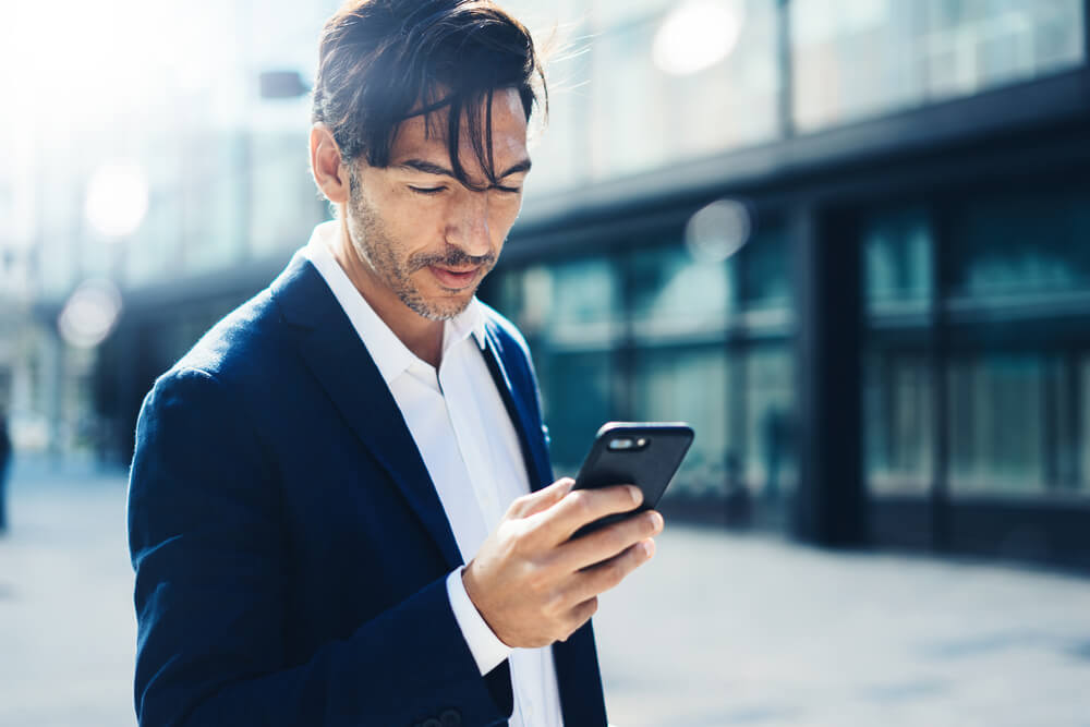 homem de negocios acessando smartphone
