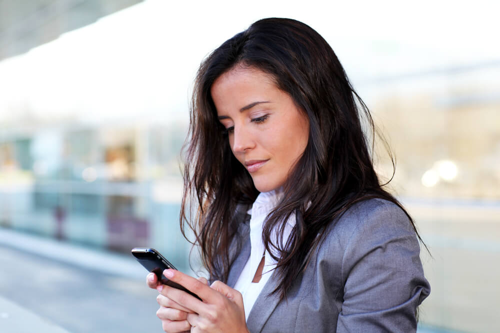 mulher séria olhando para smartphone