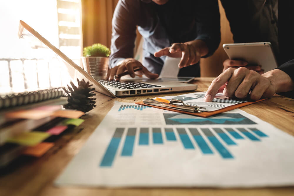 pessoas em mesa executiva com laptop, prancheta e tablet