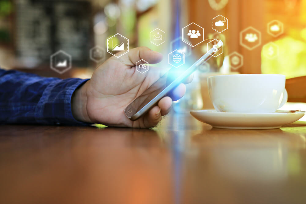pessoa acessando smartphone e simbolos