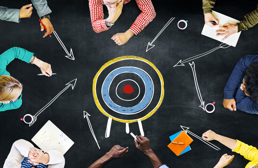 equipe de marketing e alvo representando objetivos no marketing