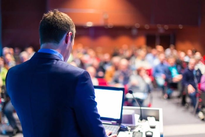 homem em frente a um laptop dando uma palestra